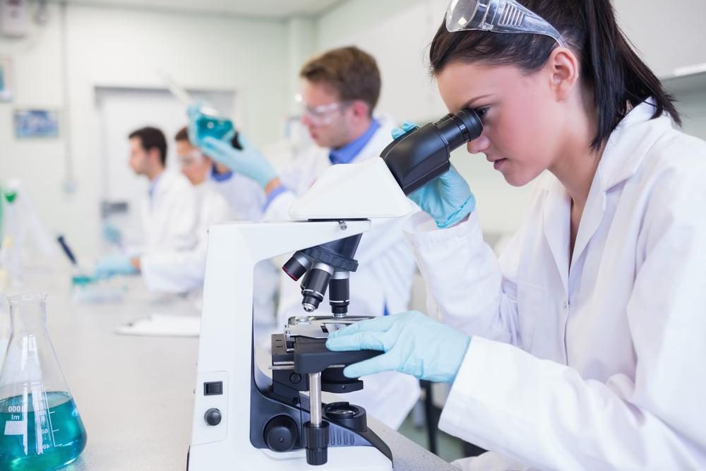 Side view of busy group of researchers working on experiments in the laboratory